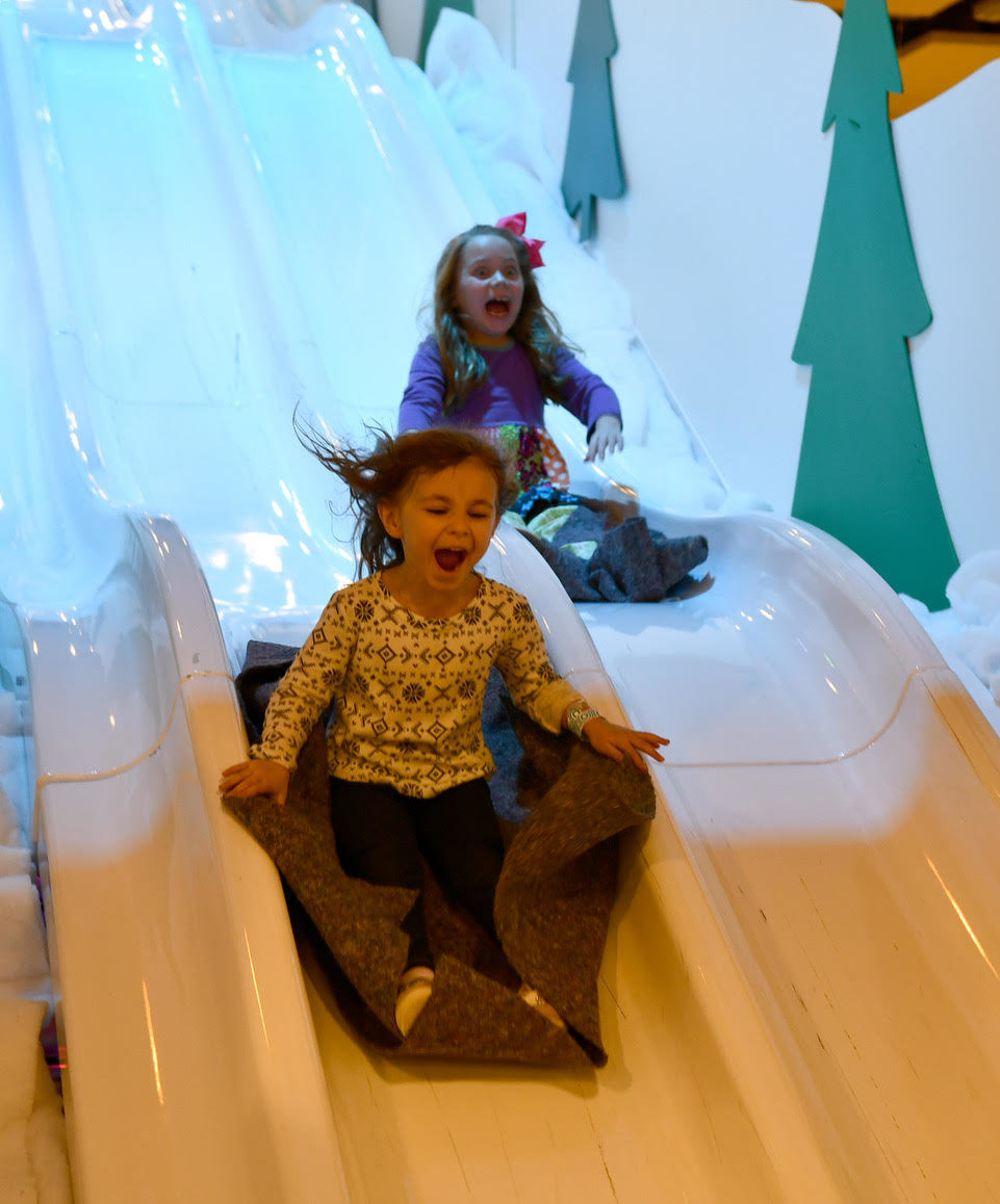 Audrey Krajceck and Julie Scott Boykin have a fun time on the Snowflake Slide. 