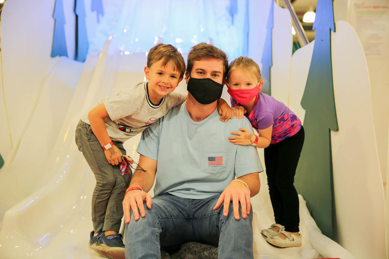 Visitors of the museum pose after a ride down the Snowflake Slide. From left to right: Fletcher Collins, Alex Collins, and Ruthie Collins.