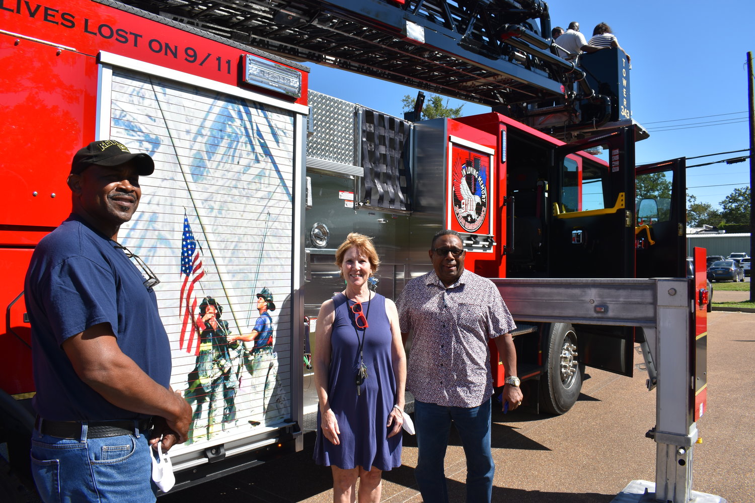 Madison County Supervisors Paul Griffin, Sheila Jones and Karl Banks stand in front of the county’s new $1.4 million fire truck that features memorialized images of 9/11. The truck was purchased in part with $750,000 in state money.
