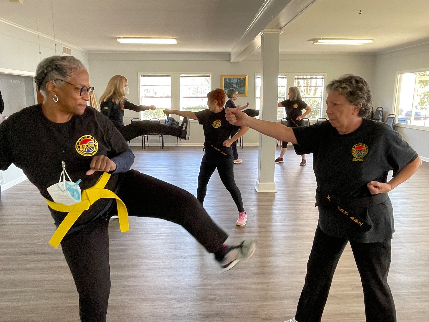 Yellow belt Paulette Grim practices fighting techniques with her classmate Diane Malouse, a black belt.