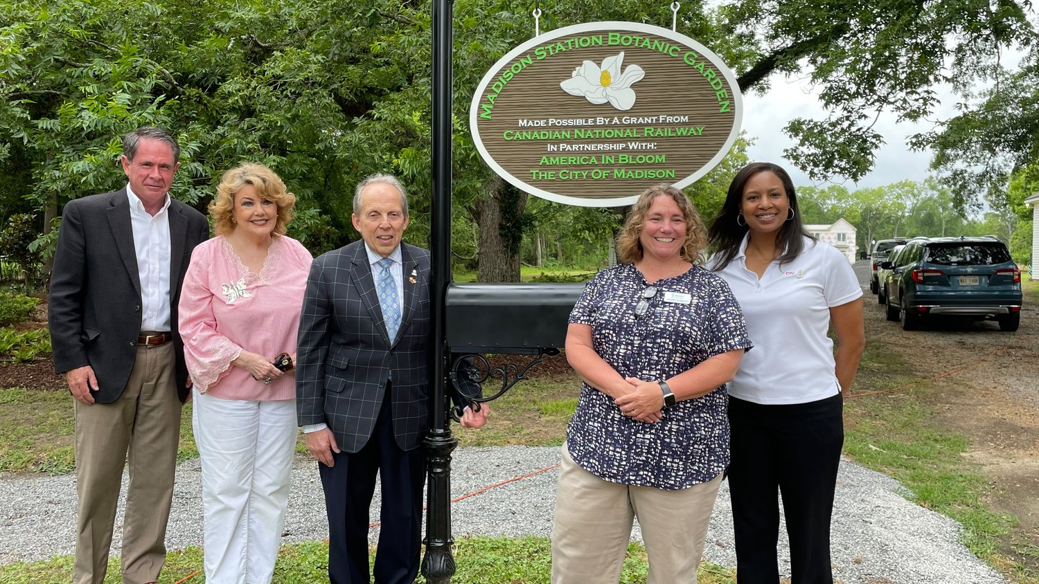 Alan Hoops, Mayor Mary Hawkins-Butler, Marvin Miller, Laura Kunkle, and Stacey Lyons pose next to the new sign hon- oring the Madison Station Botanic Garden on the historic Montgomery House Grounds.