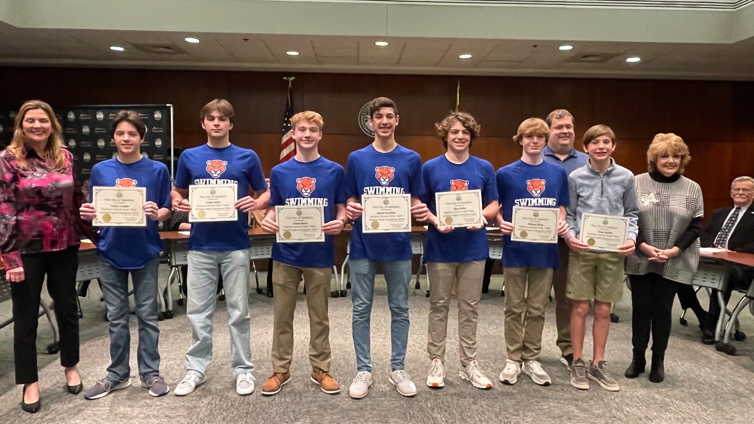 The Madison Central Boys Swim Team received certificates and recognition during the Jan. 17 Madison Board of Alderman meeting for their third-consecutive state championship win. Pictured, from left: Bridget Carmody, Aiden Allen, Clark Davis, Jaden Davillier, Henry Largen, Sam Reily, Patrick Ross, Eddie Ware, Crew Smith, and Mayor Mary Hawkins-Butler.