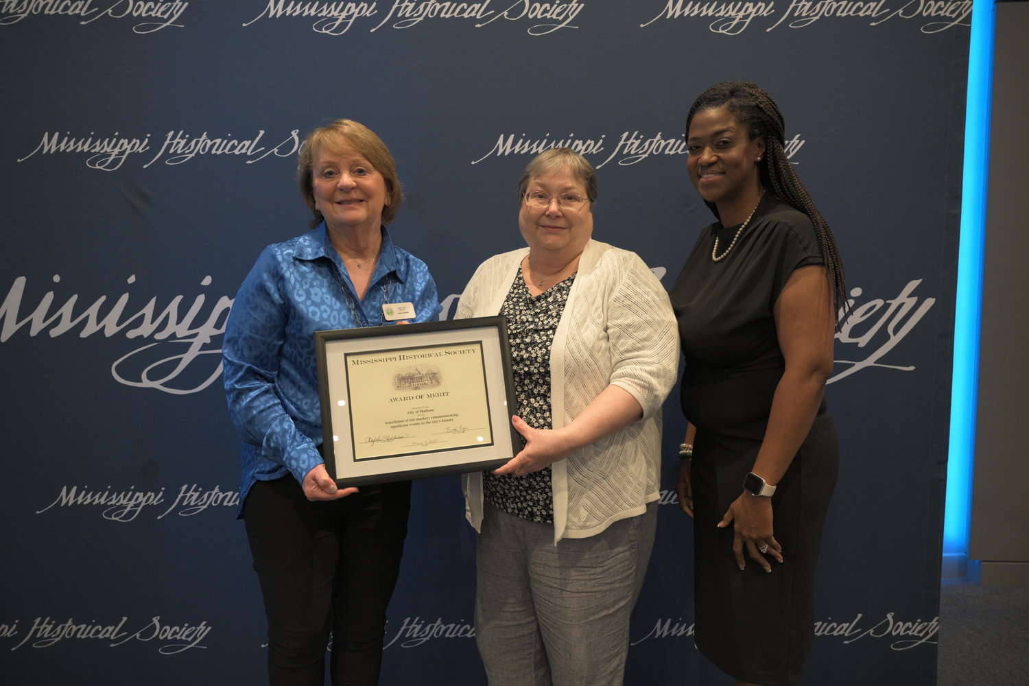 Madison Alderman Janie Jarvis, left, and Lucy Weber, project manager, accept the Award of Merit from Daphne Chamberlain, president of the Mississippi Historical Society, during the organization’s awards luncheon on March 3.