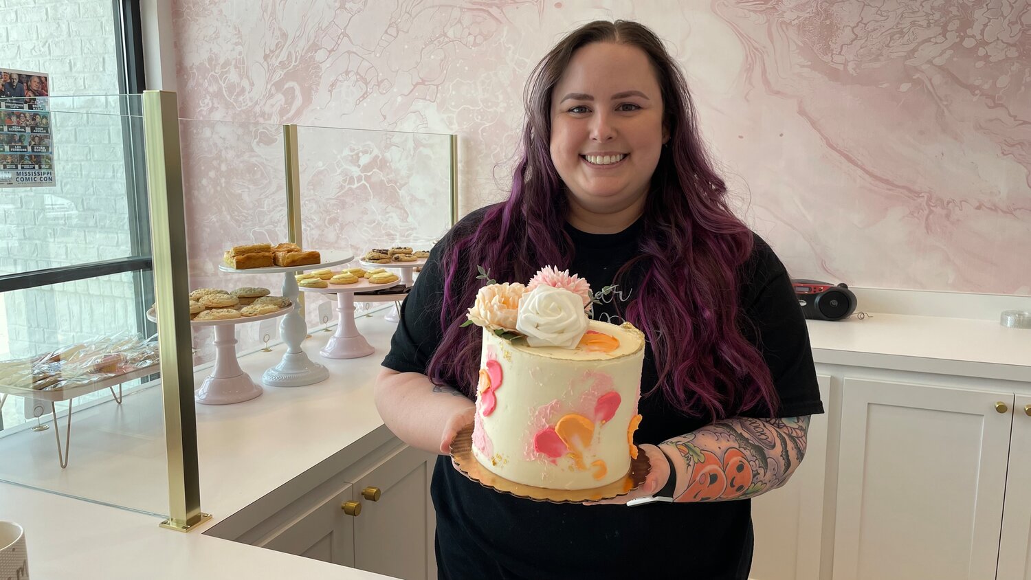 Sugar Daze owner Anna McQuillen holds up a custom cake.