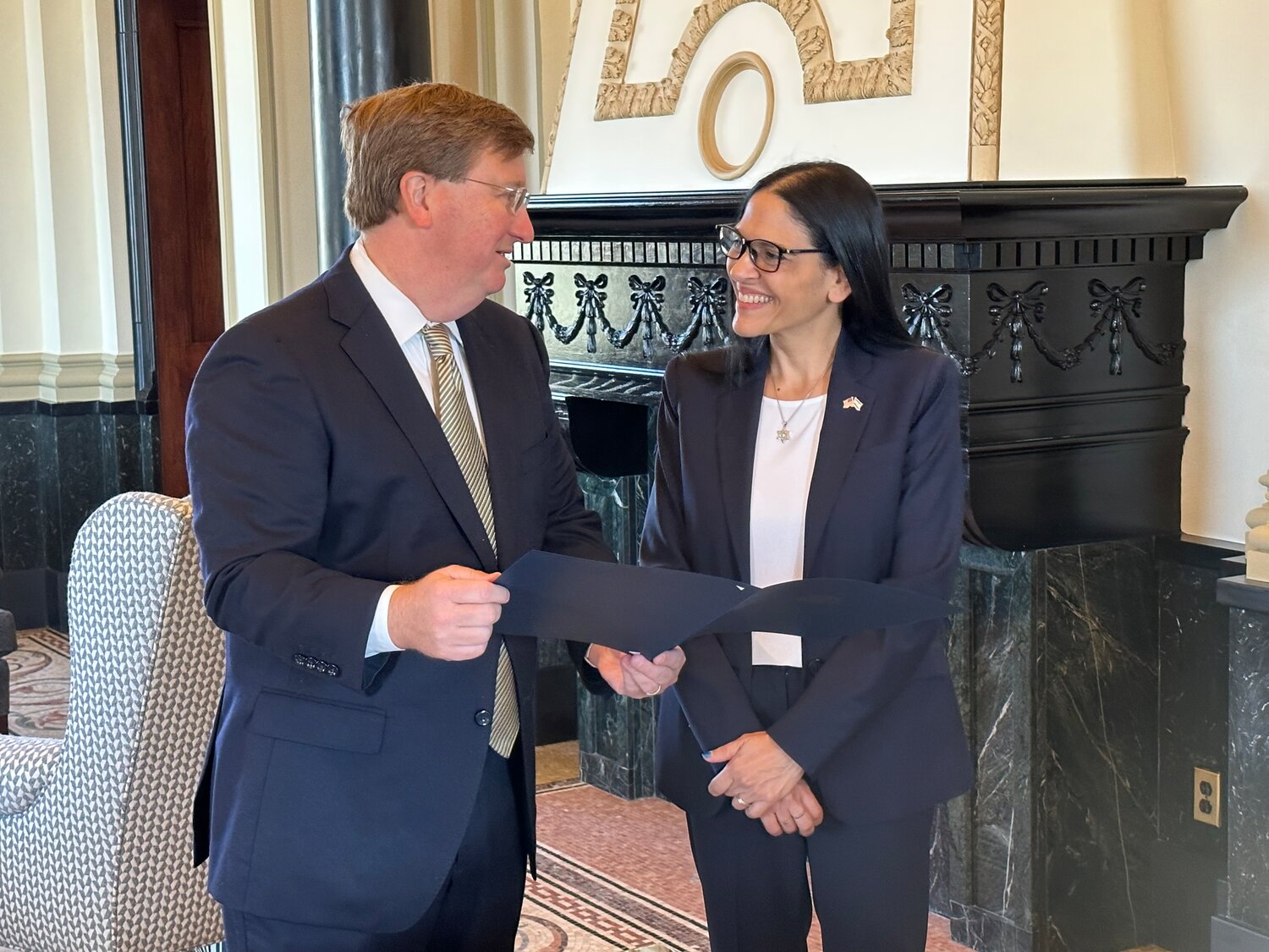 Mississippi Governor Tate Reeves hands Consul General of Israel Anat Sultan-Dadon a copy of the gubernatorial proclamation honoring Israel on its 75th Independence.